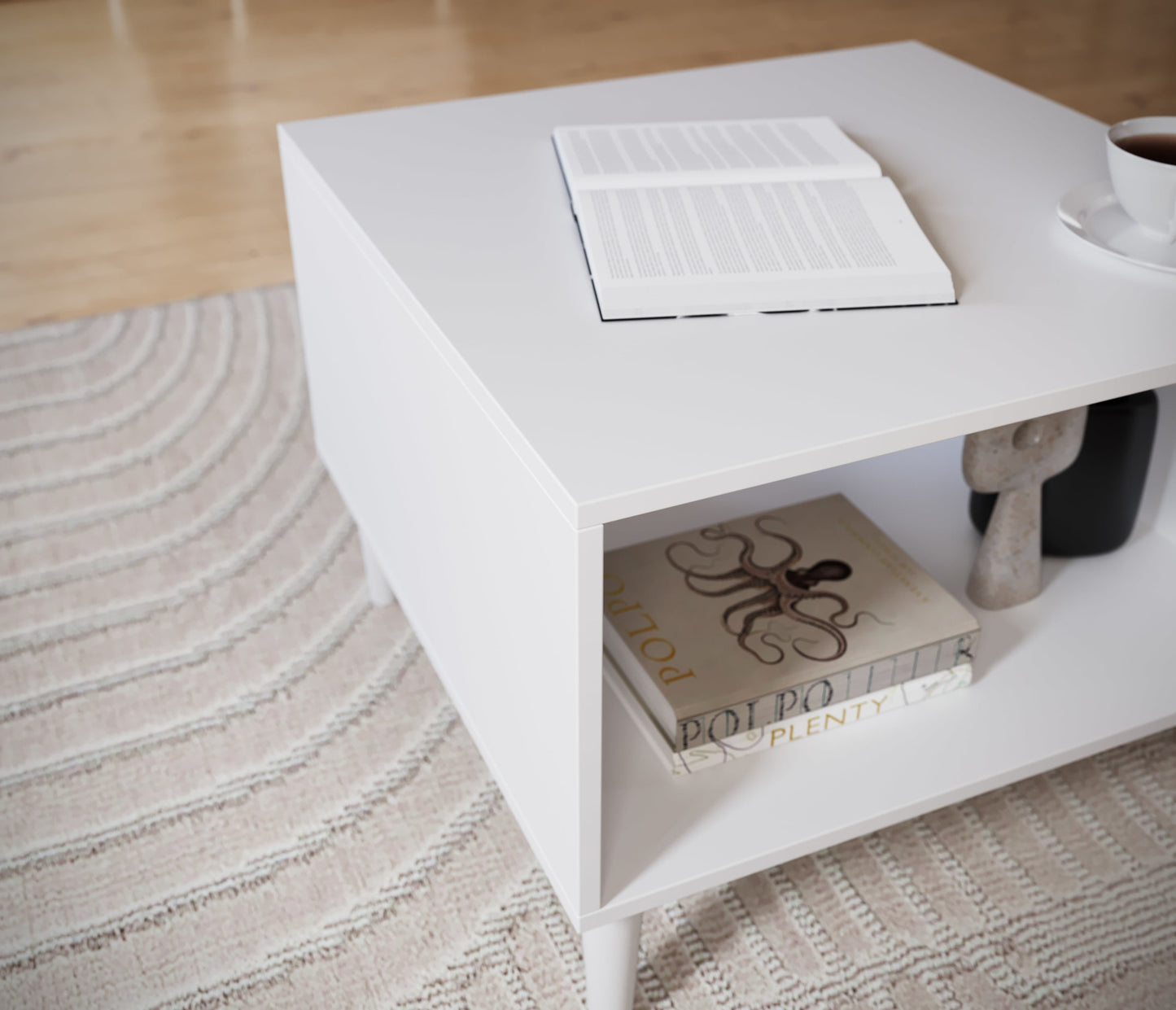 Zbliżenie na blat i półkę stolika Dullum – ułożone książki i otwarta lektura na górze, widoczne gładkie wykończenie i precyzyjne krawędzie.