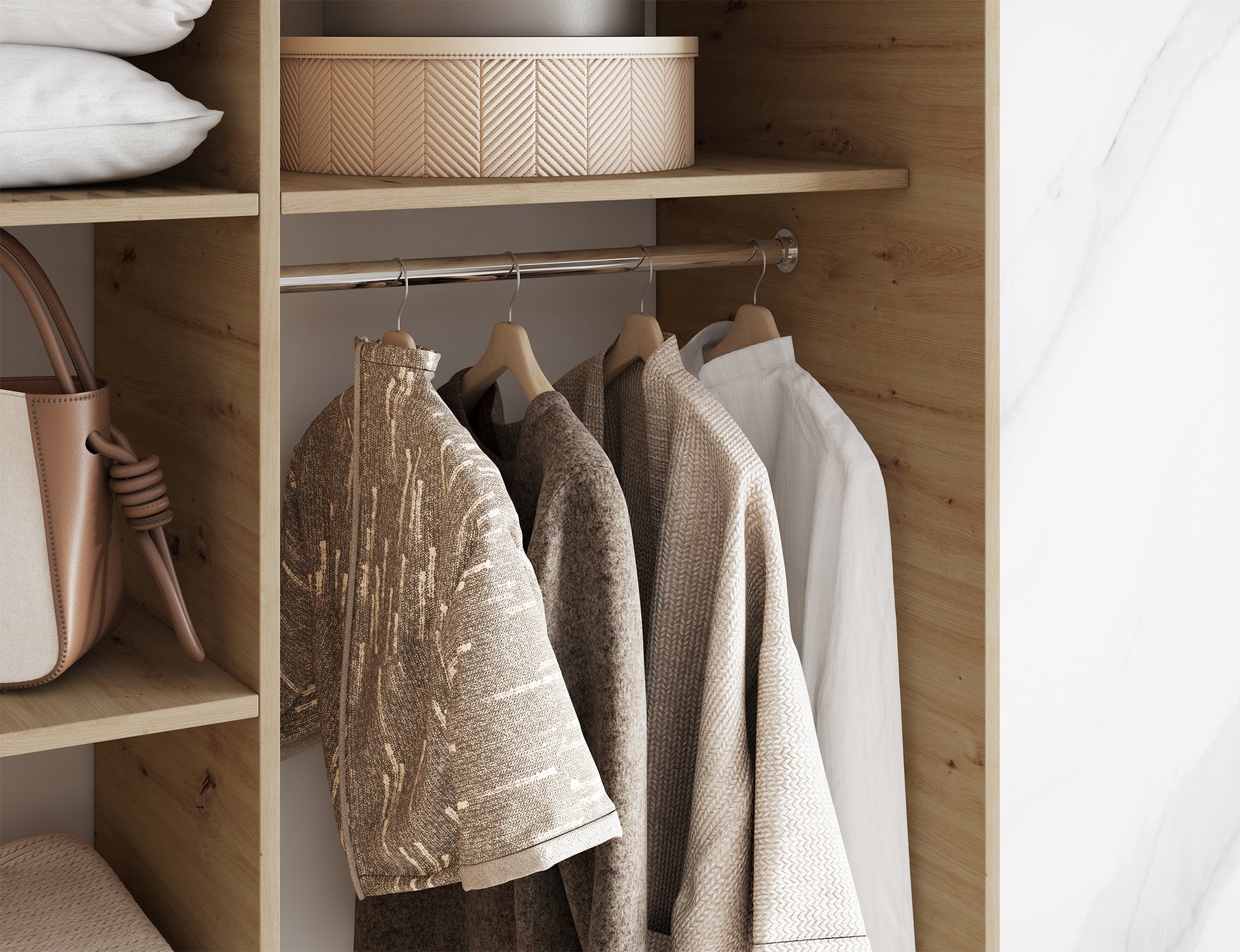 Wnętrze szafy przesuwnej Emerio III z detalem drążka i ubrań na wieszakach, widoczne również półki z dodatkami i torebką.