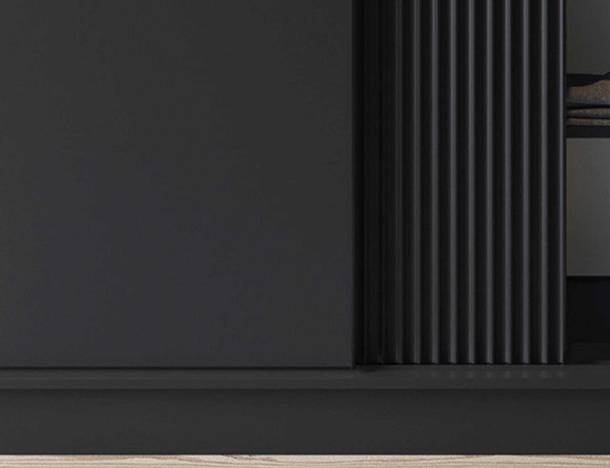 Zbliżenie na elegancki front szafy Prescco III czarnej, pionowe ryflowanie.