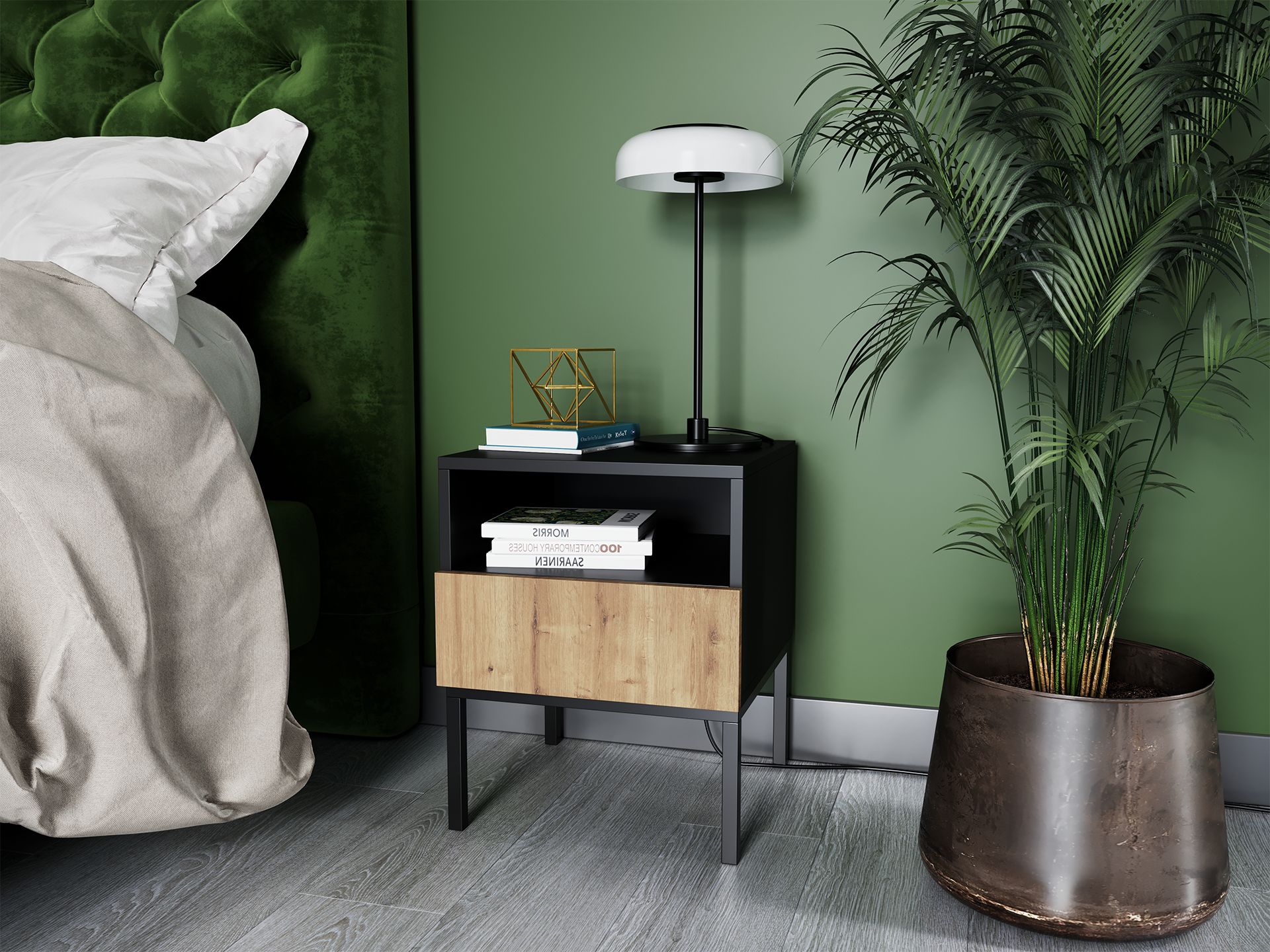 Szafka nocna Lanzzi w dębowo-czarnym wykończeniu ustawiona obok zielonego zagłówka łóżka, z lampką stołową, książkami i dekoracyjną figurką na blacie, na tle zielonej ściany i donicy z dużą palmą.