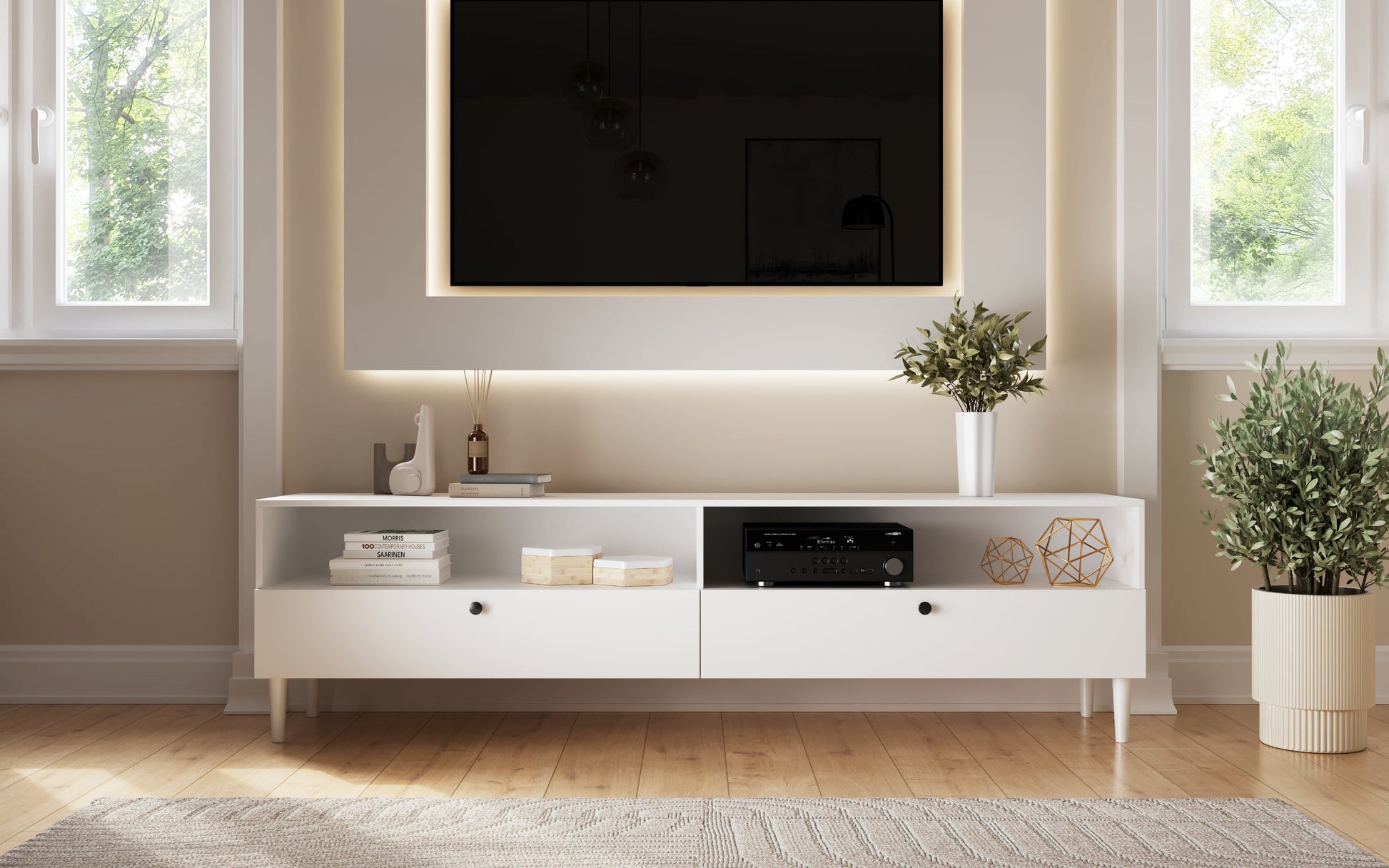 Biała szafka RTV Dullum w nowoczesnym salonie z telewizorem na ścianie i dekoracjami – stylowa aranżacja wnętrza.