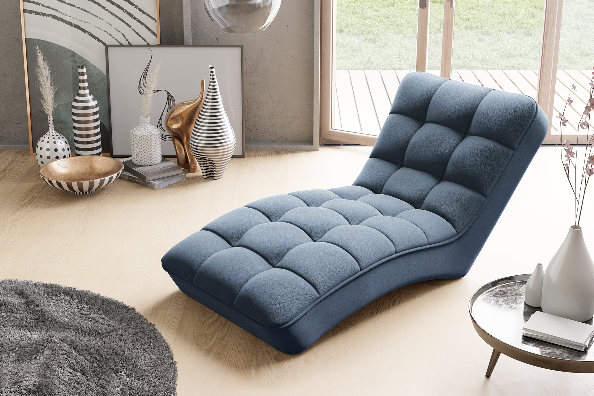 Szezlong Loren w kolorze Gojo 40 niebieski ustawiony w jasnym wnętrzu z dostępem do tarasu, otoczony designerskimi wazonami i miękkim dywanem.