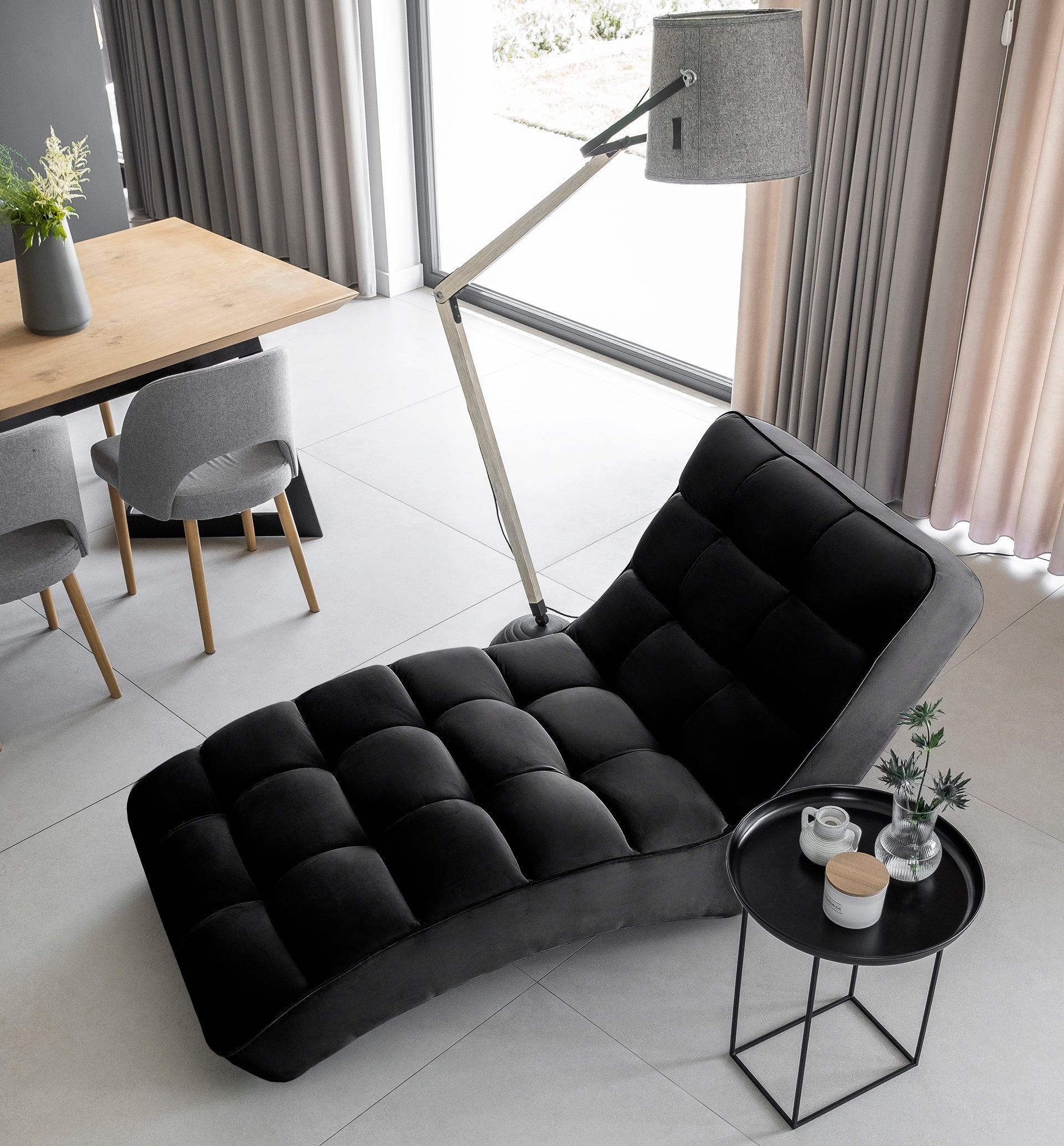 Widok z góry na szezlong Loren w kolorze Loco 10 czarny w nowoczesnym wnętrzu obok stołu jadalnianego i stolika pomocniczego.