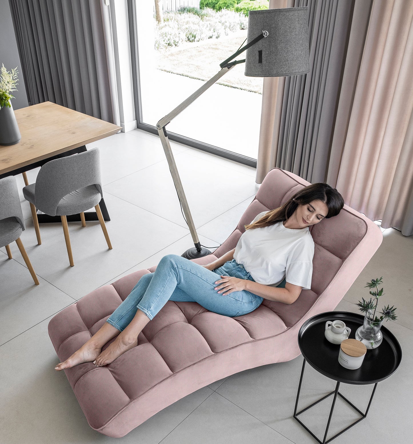 Kobieta relaksująca się na szezlongu Loren Loco 24 jasnoróżowy w eleganckim wnętrzu.