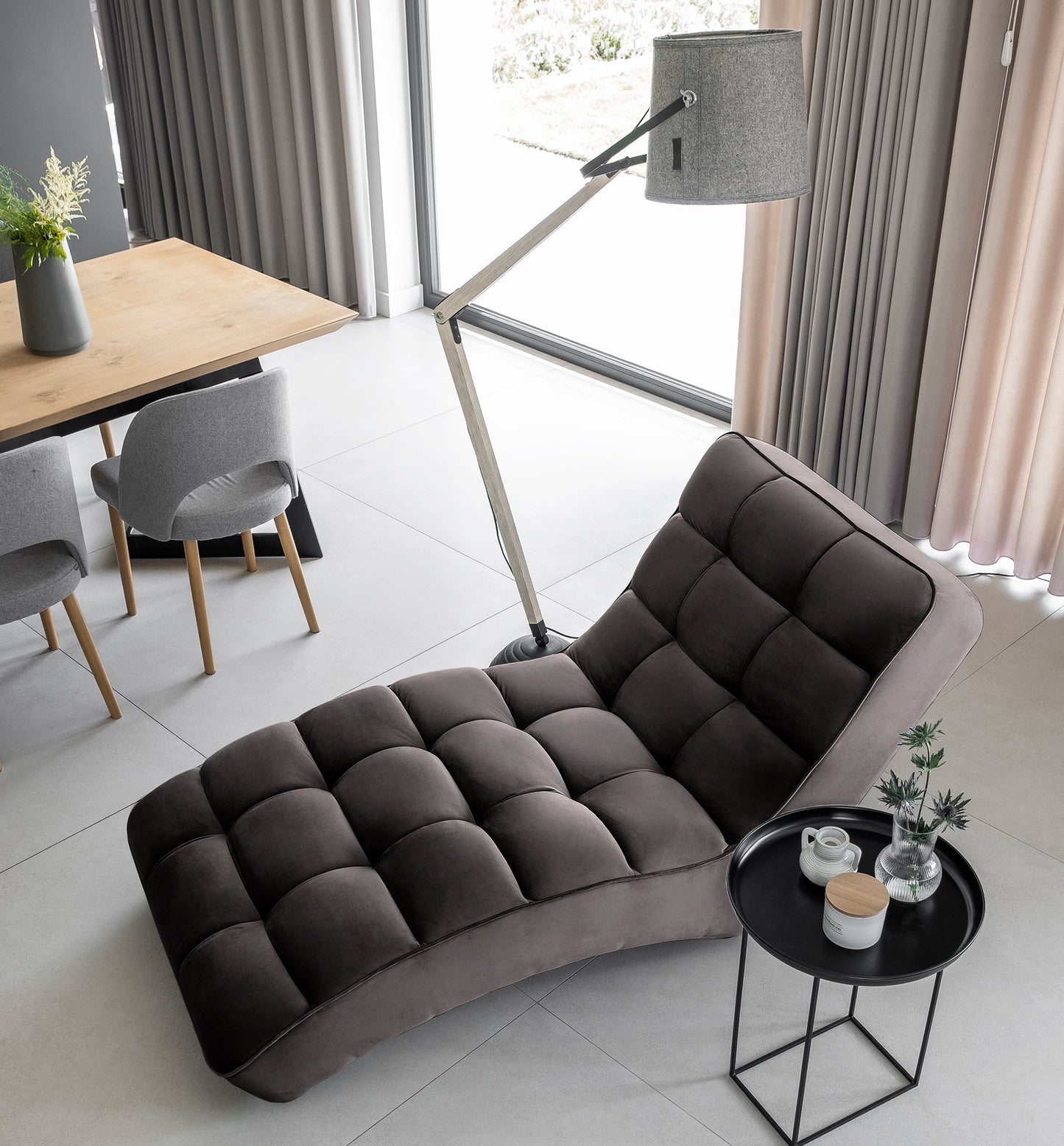 Widok z góry na ciemnoszary szezlong Loren w jasnym wnętrzu z elementami skandynawskiego designu.