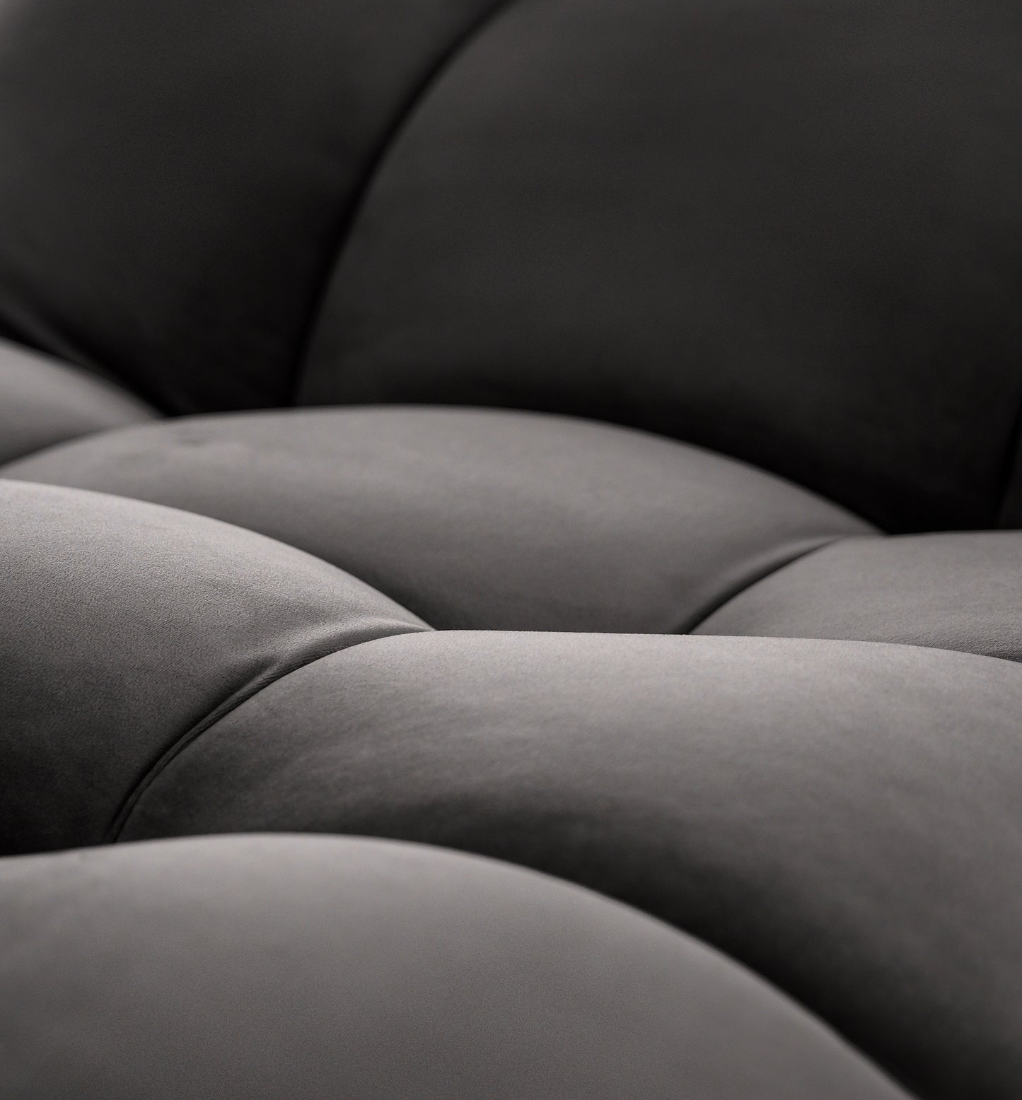 Zbliżenie tapicerki siedziska szezlonga Loren w kolorze ciemnoszarym, ukazujące subtelny połysk i wyraziste przeszycia.