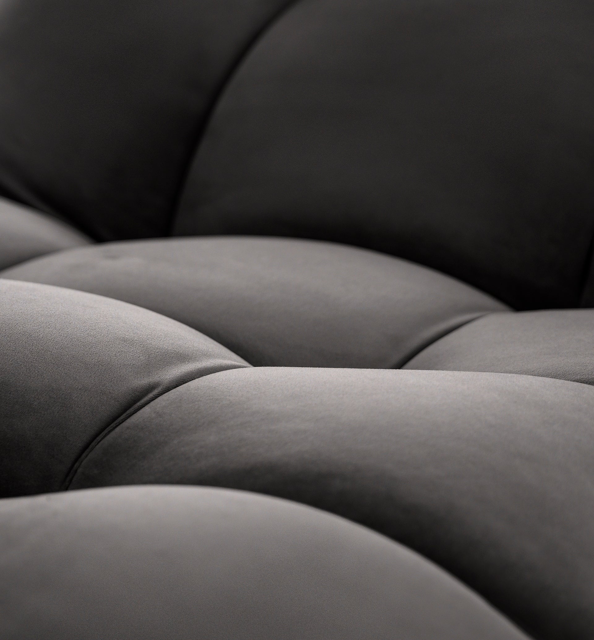 Zbliżenie tapicerki siedziska szezlonga Loren w kolorze ciemnoszarym, ukazujące subtelny połysk i wyraziste przeszycia.