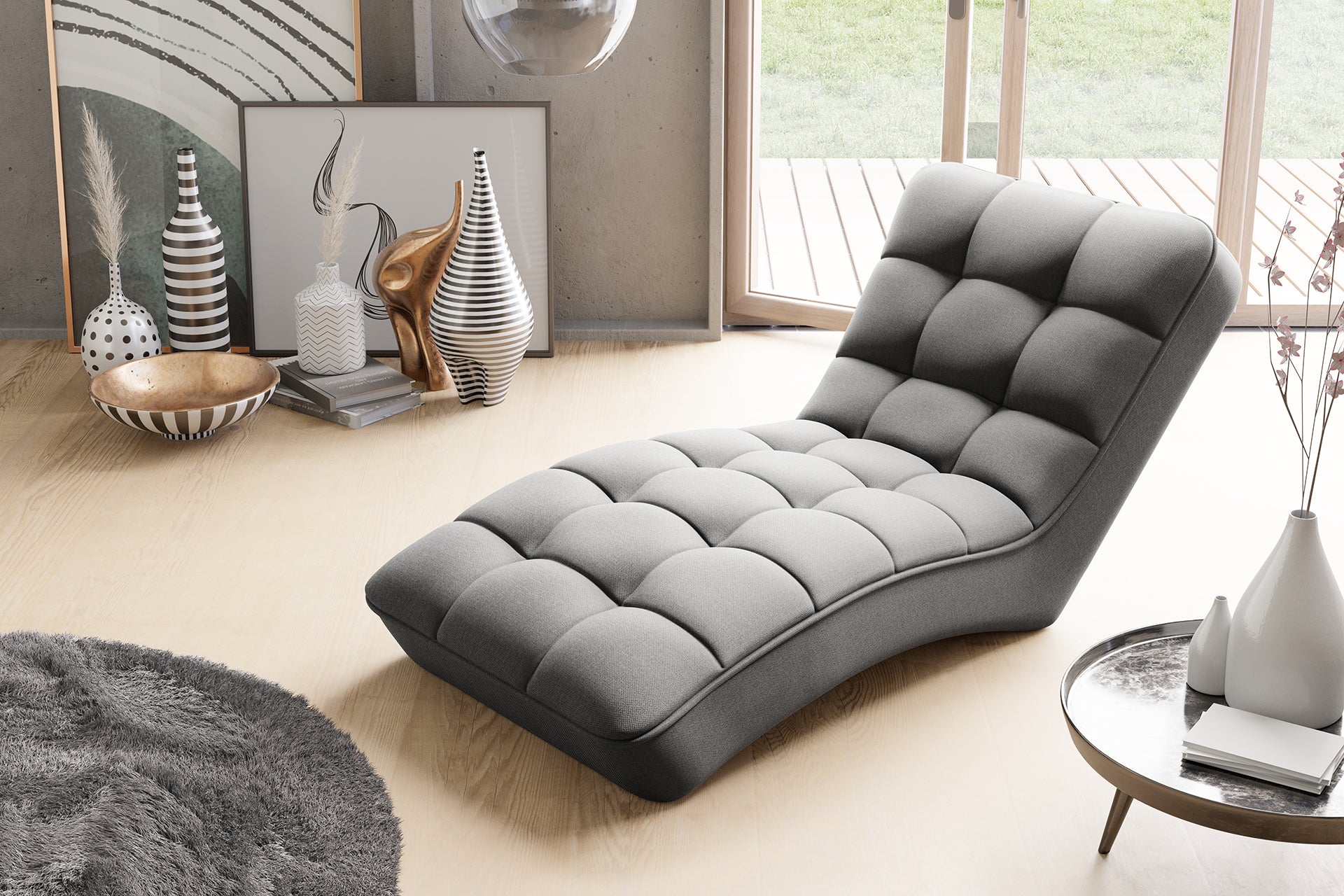 Nowoczesny szezlong Loren w jasnoszarym kolorze Vero 04 na tle przeszklonych drzwi tarasowych, otoczony designerskimi dodatkami i okrągłym stolikiem kawowym.