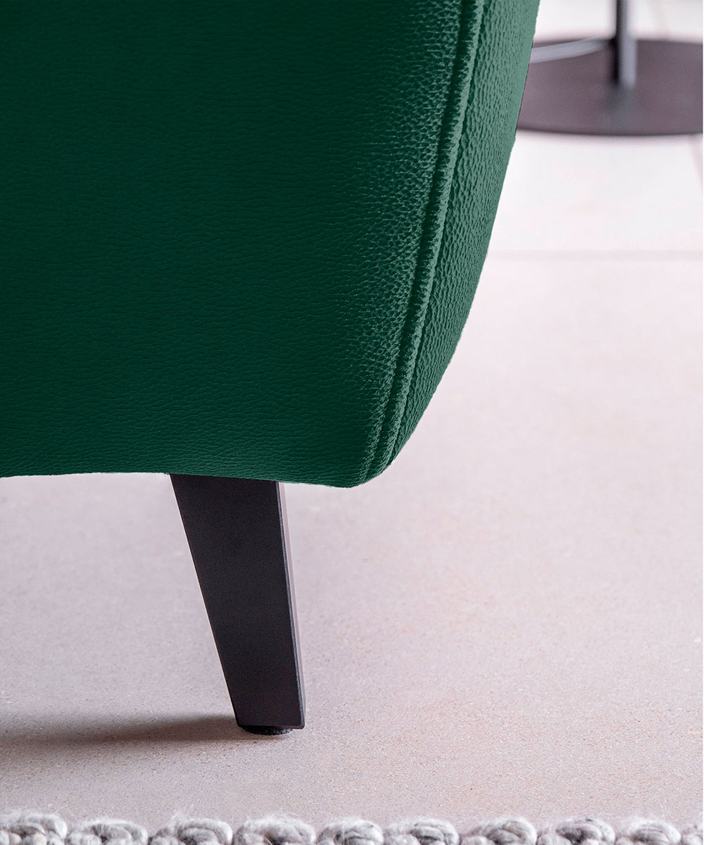 Detal narożnika Noble Nube 35 ukazujący ergonomiczny zagłówek oraz strukturę zielonej tkaniny o subtelnym wykończeniu. Designerski narożnik wypoczynkowy do loftowych, glamour i eleganckich wnętrz salonowych.