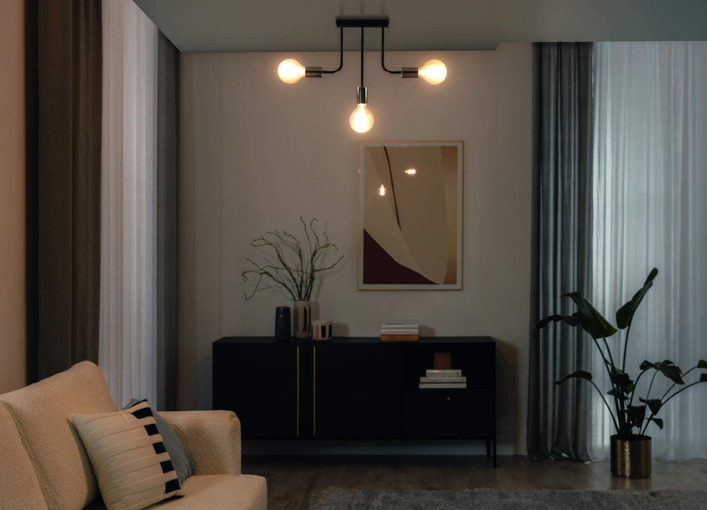 Żyrandol Indigeo 48x48 cm z trzema żarówkami dekoracyjnymi o ciepłym świetle w nowoczesnym salonie.