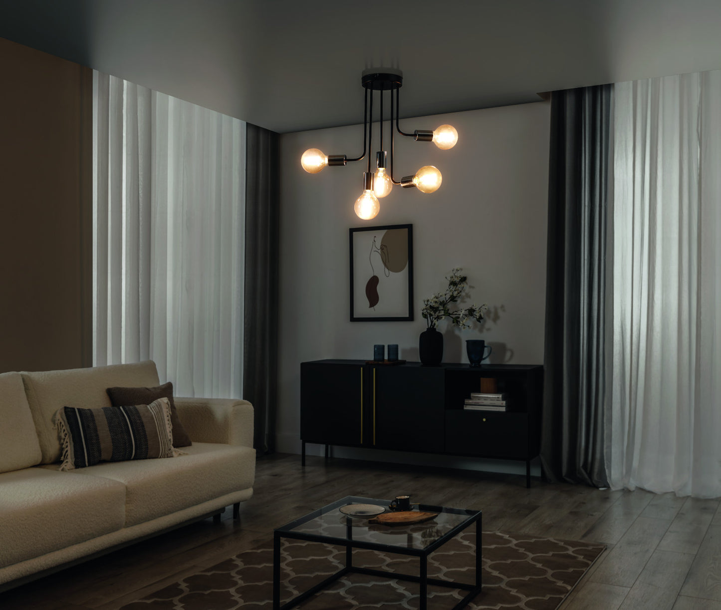 Żyrandol Indigeo I 47x55 cm z pięcioma źródłami światła o ciepłej barwie w nowoczesnym salonie z sofą i czarną komodą.