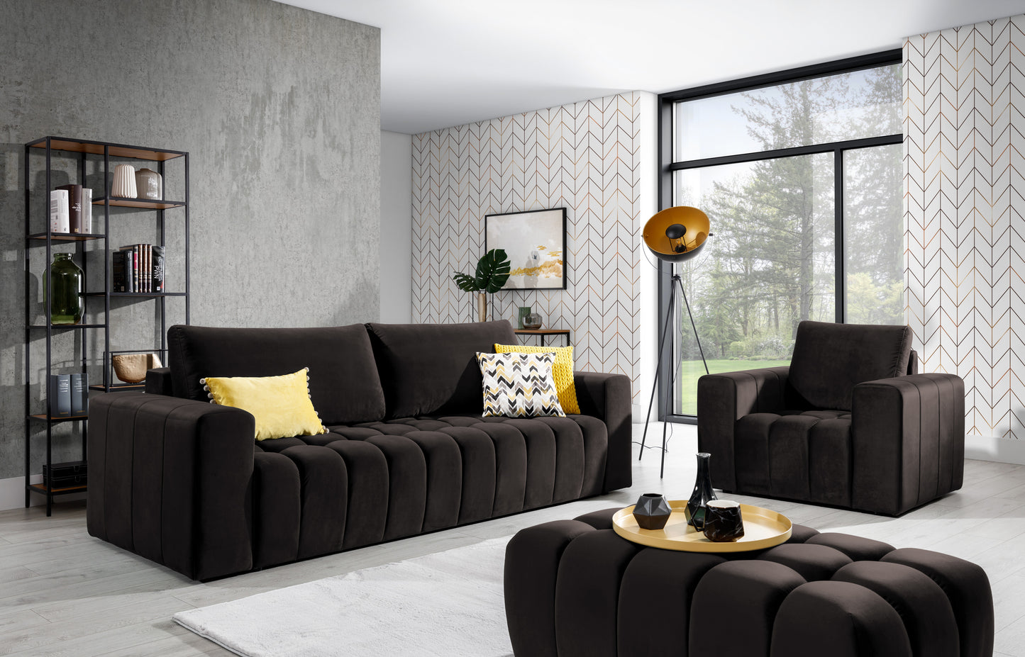 Zestaw wypoczynkowy Lazaro w kolorze Monolith 29 brązowy w jasnym salonie z dużym oknem i wzorzystą tapetą. W skład kompletu wchodzą sofa, fotel i pufa, uzupełnione o żółte poduszki i nowoczesne dodatki.”