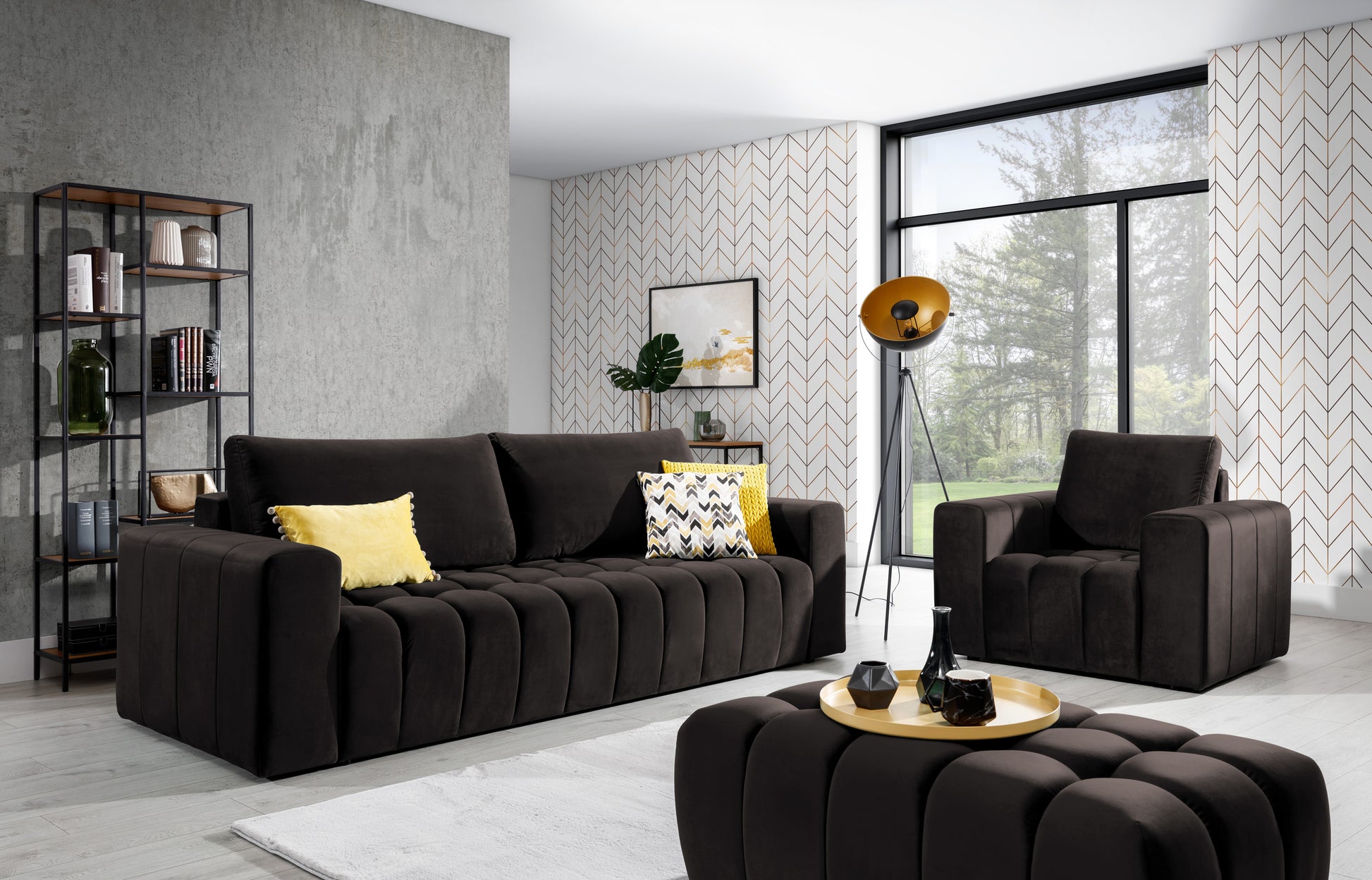 Zestaw wypoczynkowy Lazaro w kolorze Monolith 29 brązowy w jasnym salonie z dużym oknem i wzorzystą tapetą. W skład kompletu wchodzą sofa, fotel i pufa, uzupełnione o żółte poduszki i nowoczesne dodatki.”