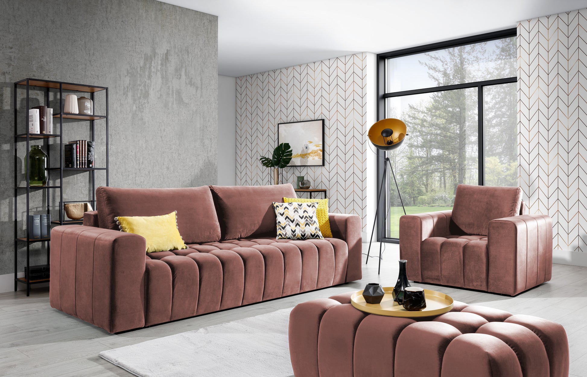 Zestaw wypoczynkowy Lazaro w kolorze różowym Nube 20 w nowoczesnym salonie – sofa, fotel i pufa ustawione na jasnym dywanie, w otoczeniu geometrycznych wzorów, industrialnego regału i żółtych dodatków.
