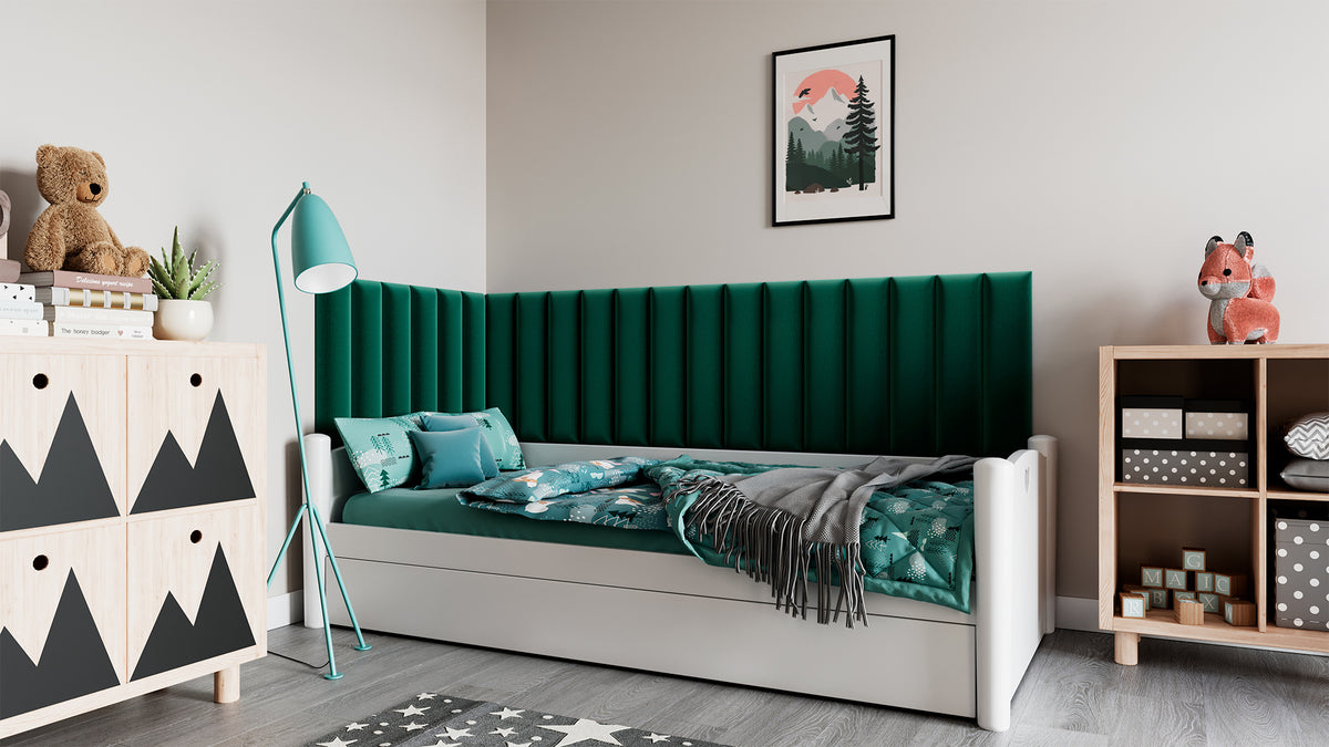 Przytulny pokój z białym łóżkiem i biurkiem; na ścianie za wezgłowiem wisi zielony panel akustyczny Quadratta IX Monolith 37, pełniący rolę tapicerowanego zagłówka i izolacji akustycznej.